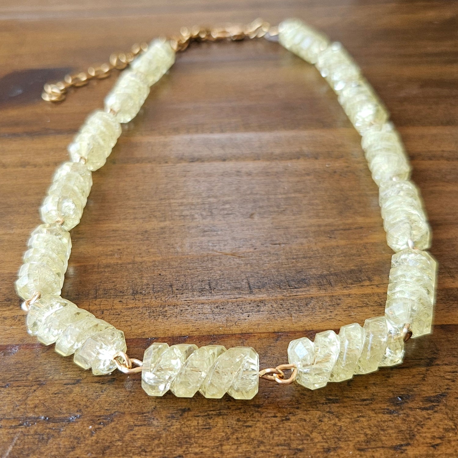 Necklace with light yellow-colored beads on a wooden surface