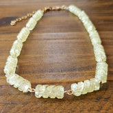 Necklace with light yellow-colored beads on a wooden surface