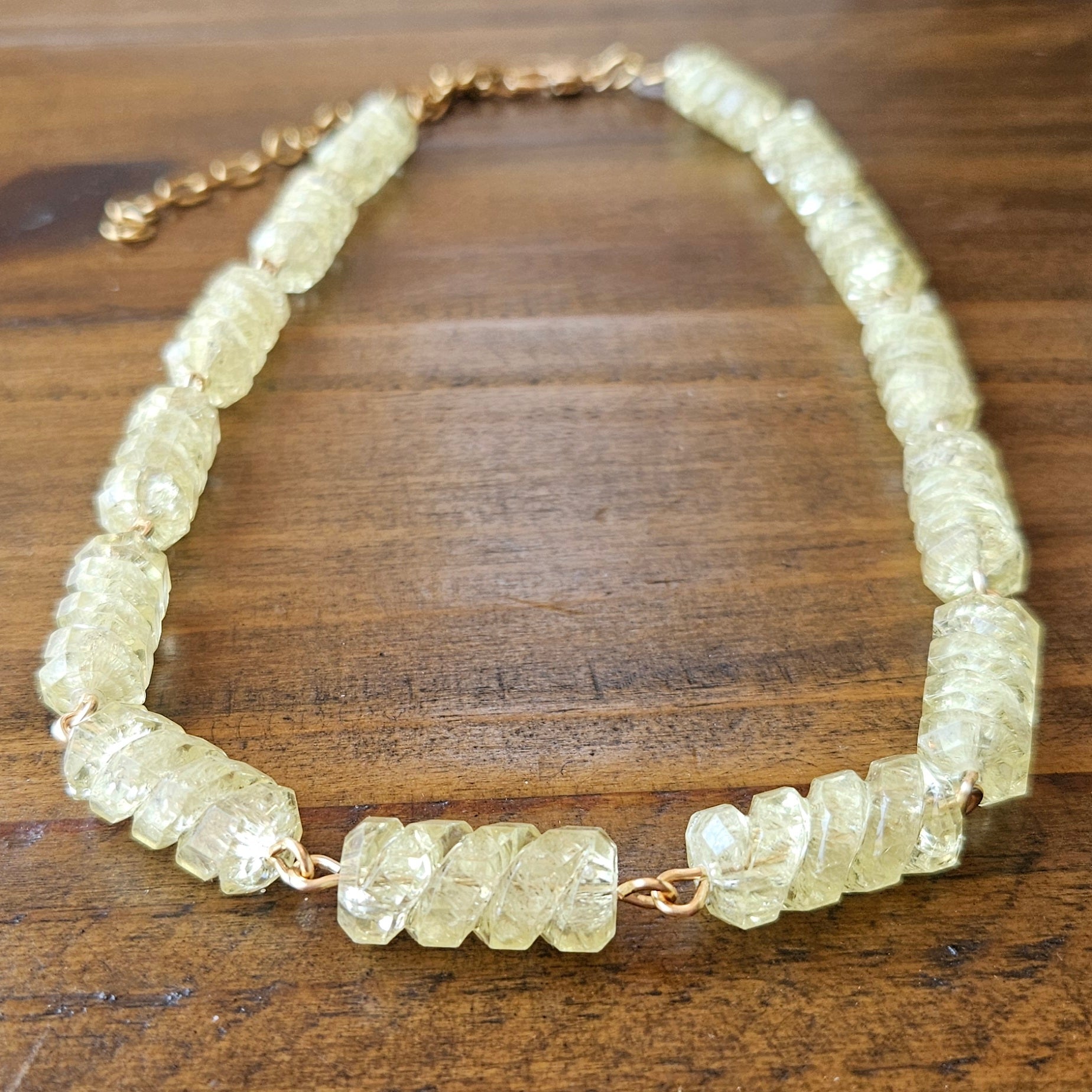 Necklace with light yellow-colored beads on a wooden surface