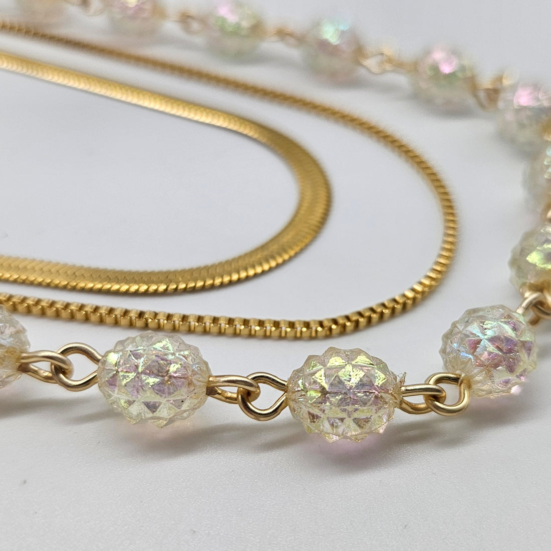 Close up of gold chain with crystal beads on a light background