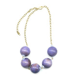 Necklace with purple beads and a gold chain on a white background
