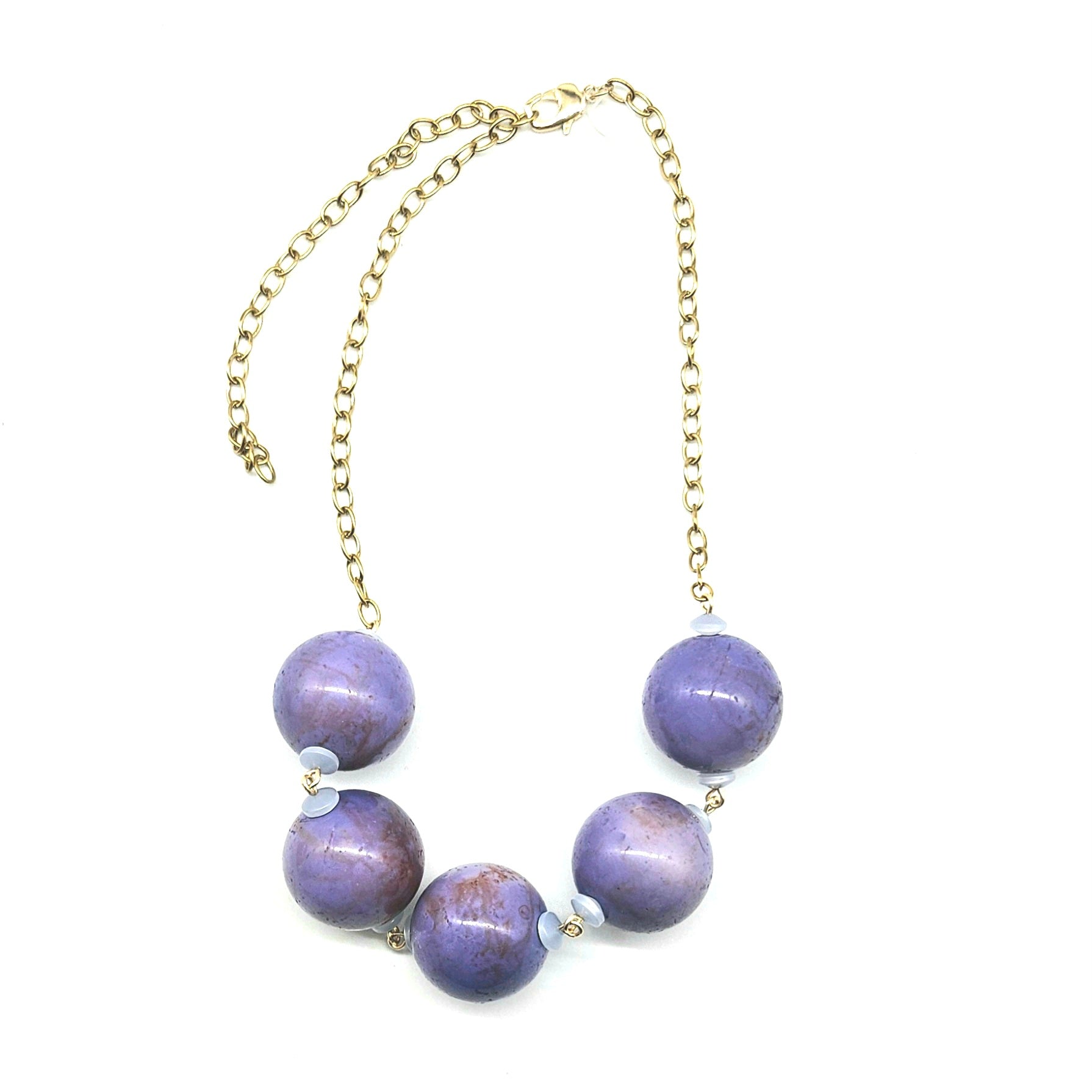 Necklace with purple beads and a gold chain on a white background
