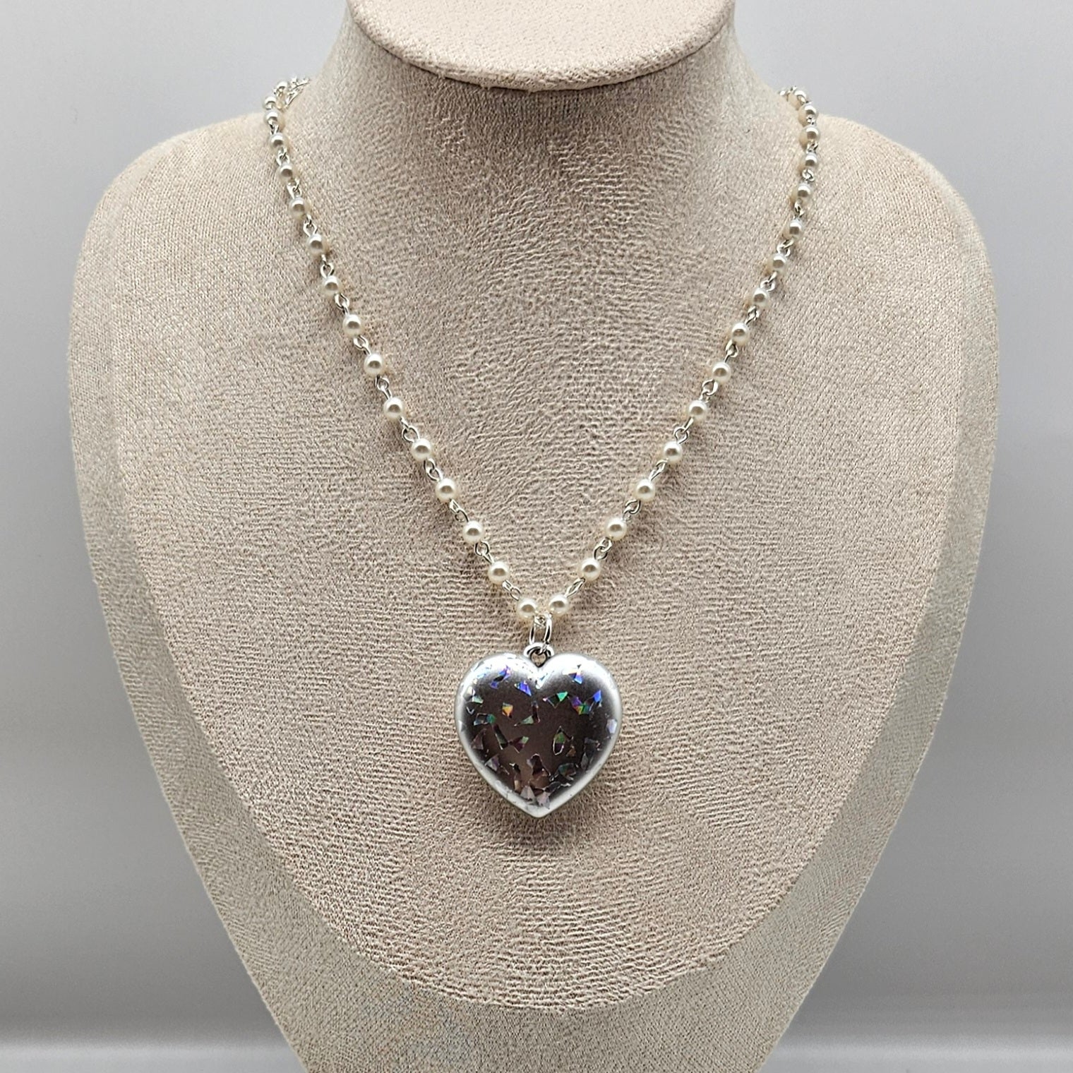 Necklace with a heart-shaped pendant on a mannequin bust against a gray background
