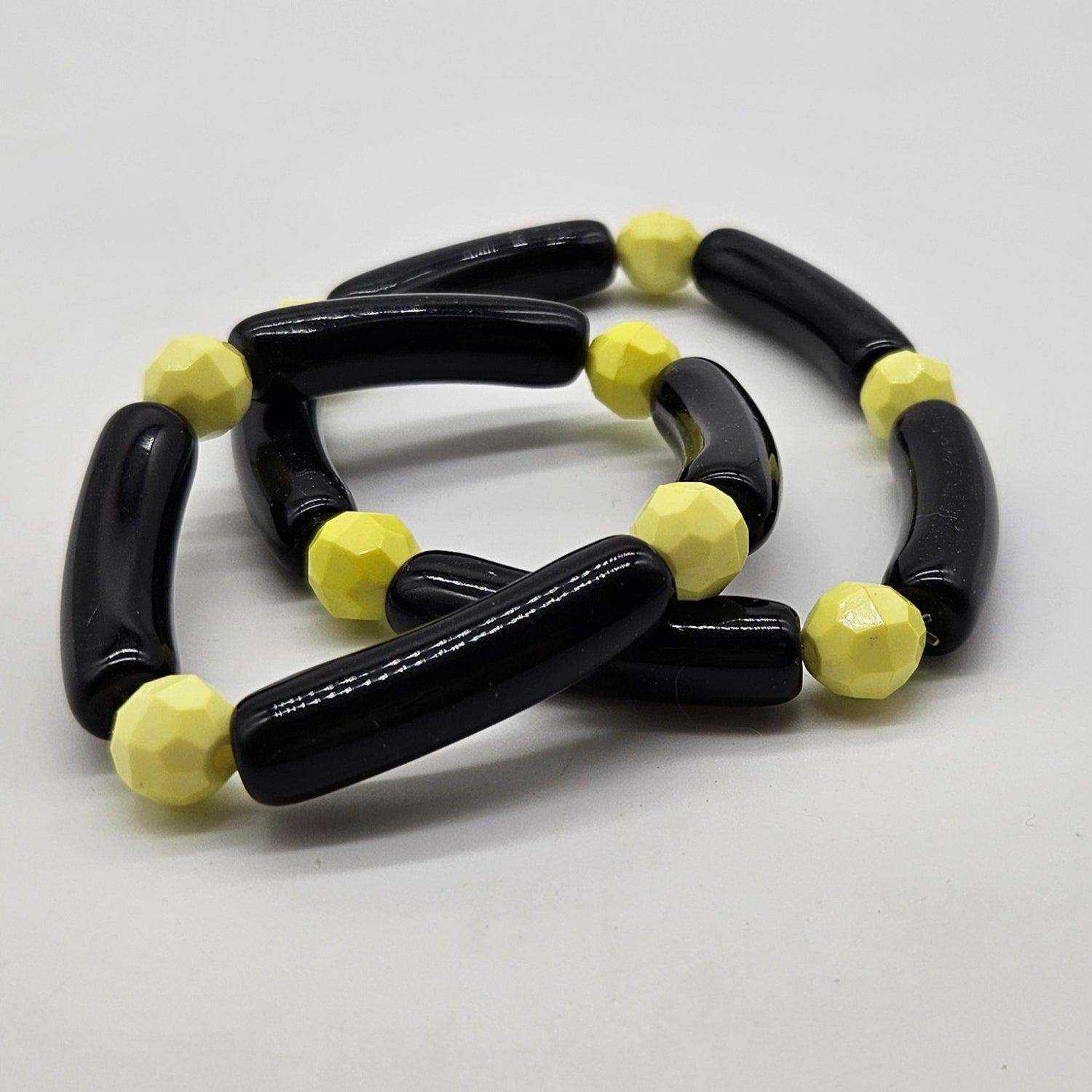 Black and yellow beaded bracelets on a white background