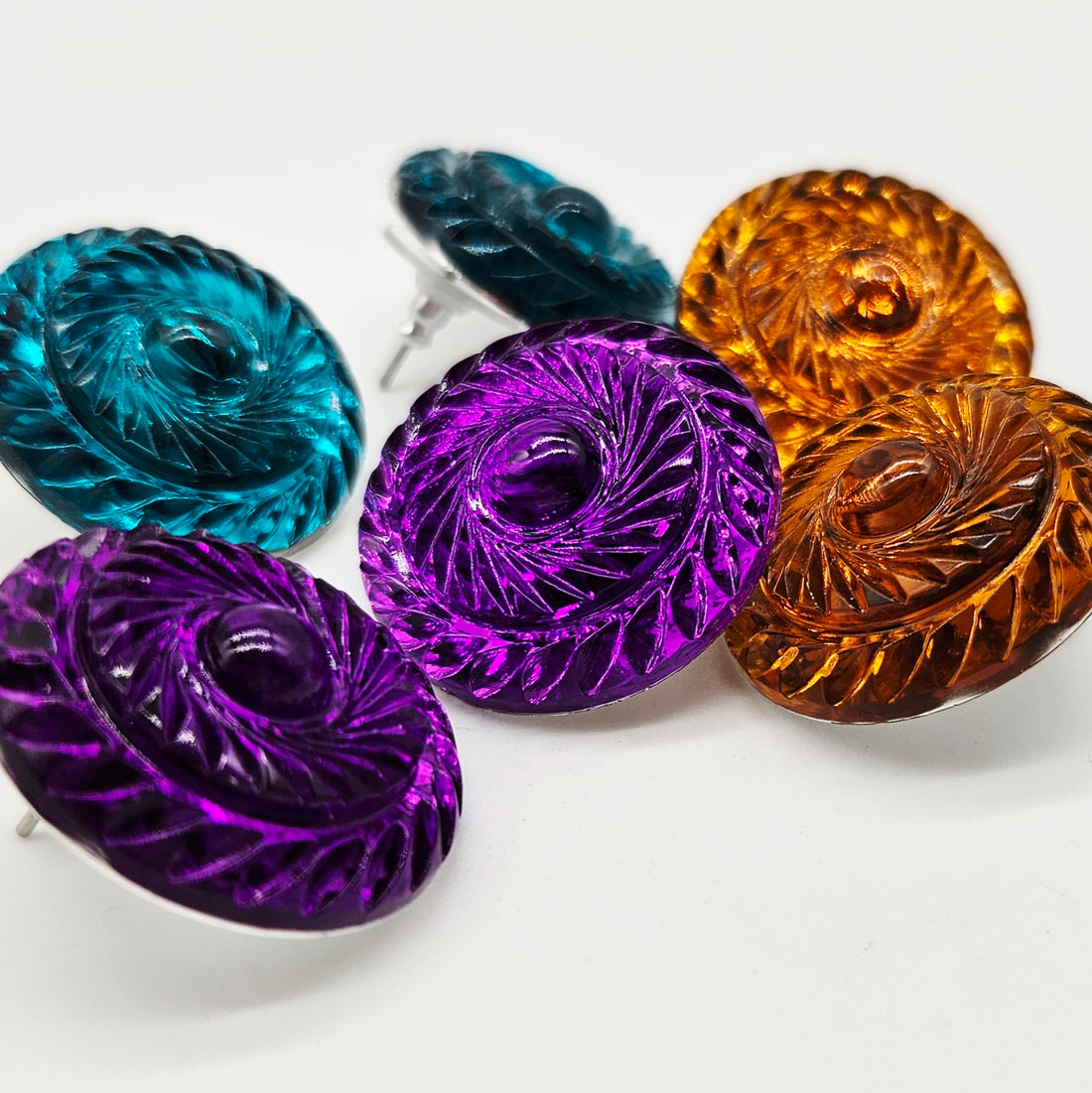 Set of colorful textured lucite earrings on a white background
