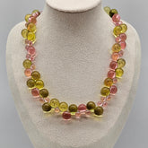 Necklace with multicolored beads on a mannequin bust against a gray background