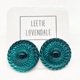 Pair of teal earrings with a decorative pattern on a white background with &