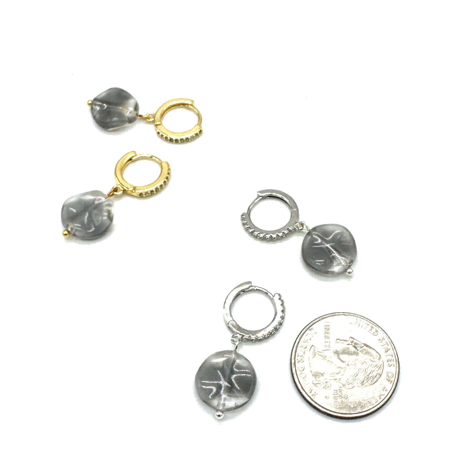 Small silver hoop earrings with gray stones on a white background, shown with a quarter for scale.