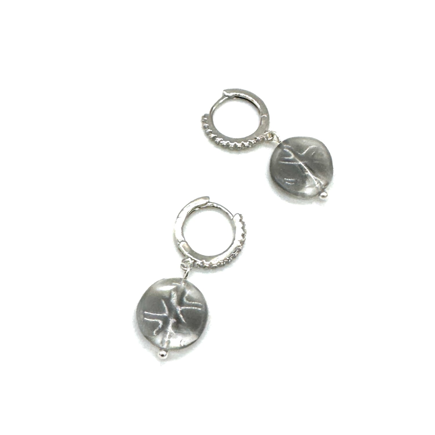 Pair of silver hoop earrings with engraved designs on a white background