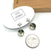Pair of earrings with star and round stone design on a white card with &