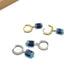 Pair of hoop earrings with blue cube beads on a white background
