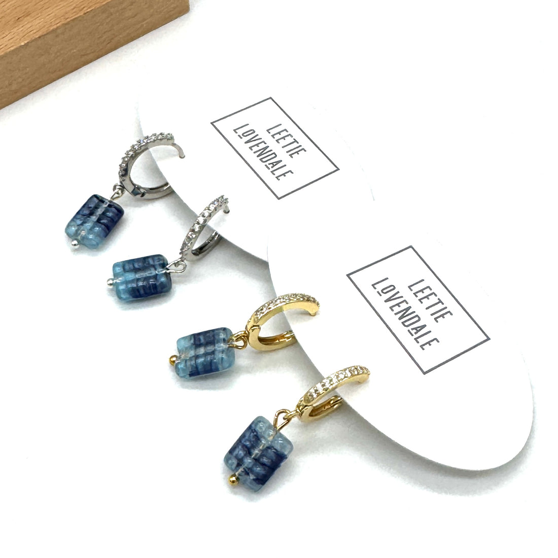 Jewelry set with blue beads and gold accents on a white background with &