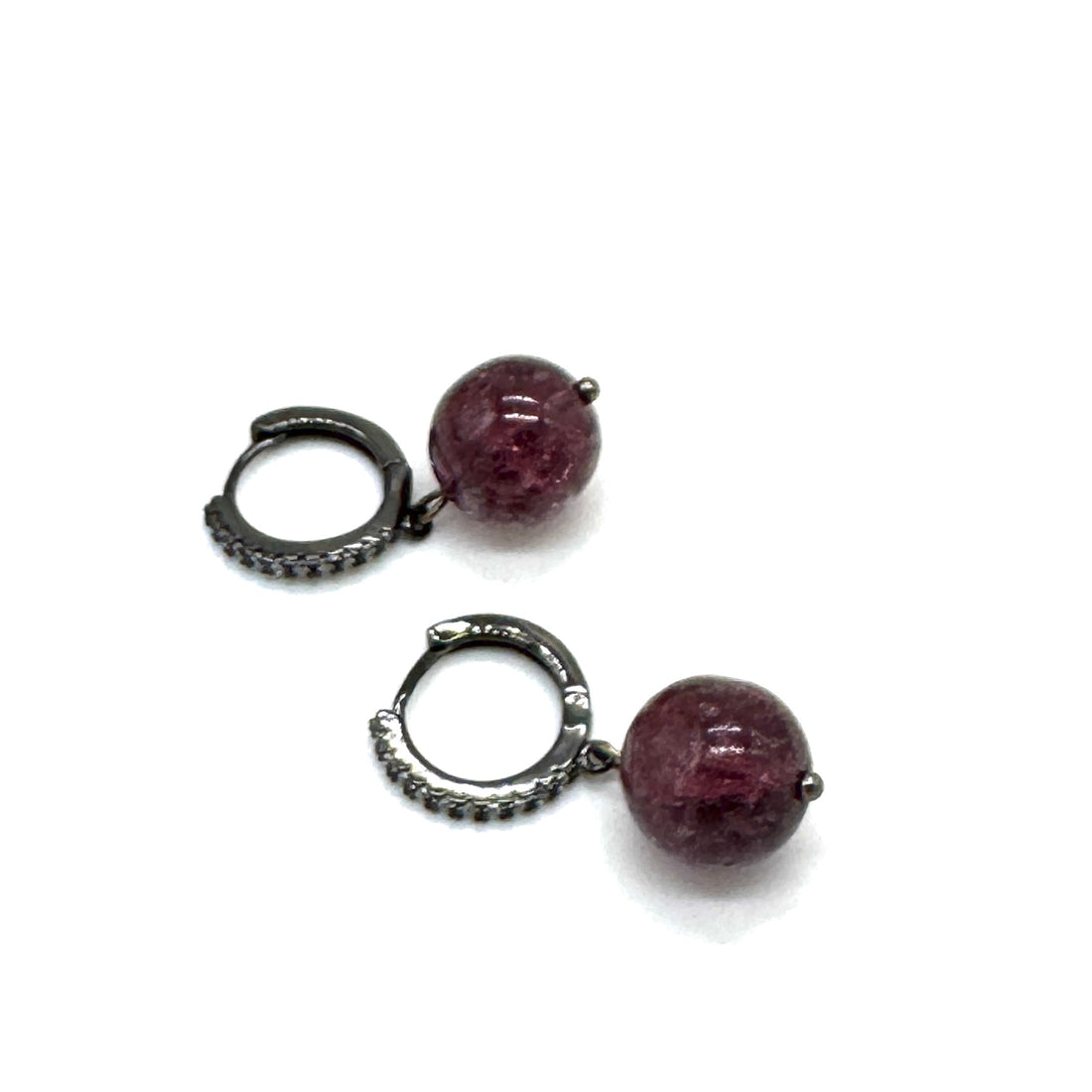 Pair of earrings with purple beads and silver hooks on a white background