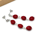 Red beaded bracelet with silver accents on a white background
