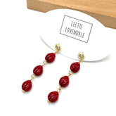 Red beaded earrings on a white card with &