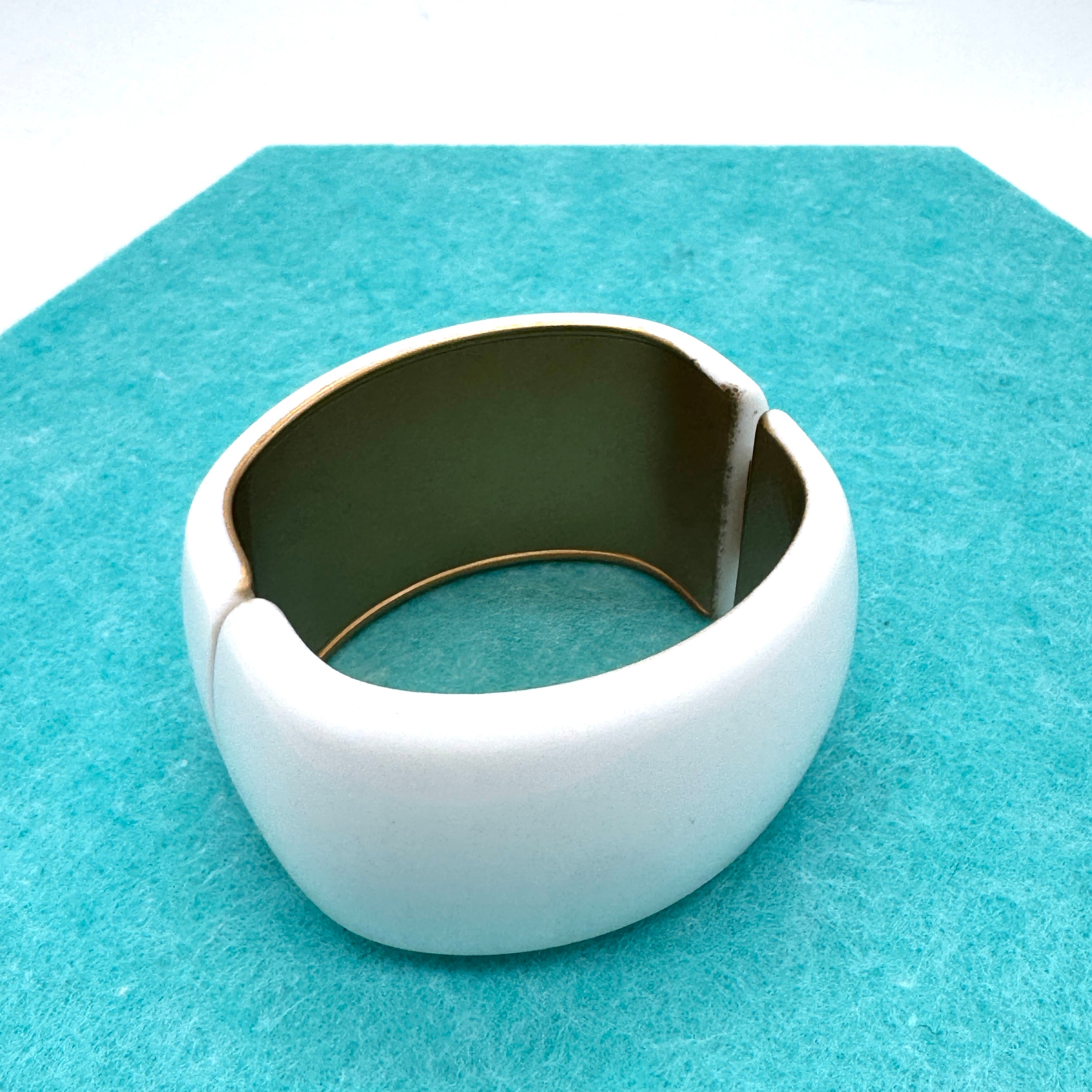 white lucite clamper cuff bracelet on a blue background