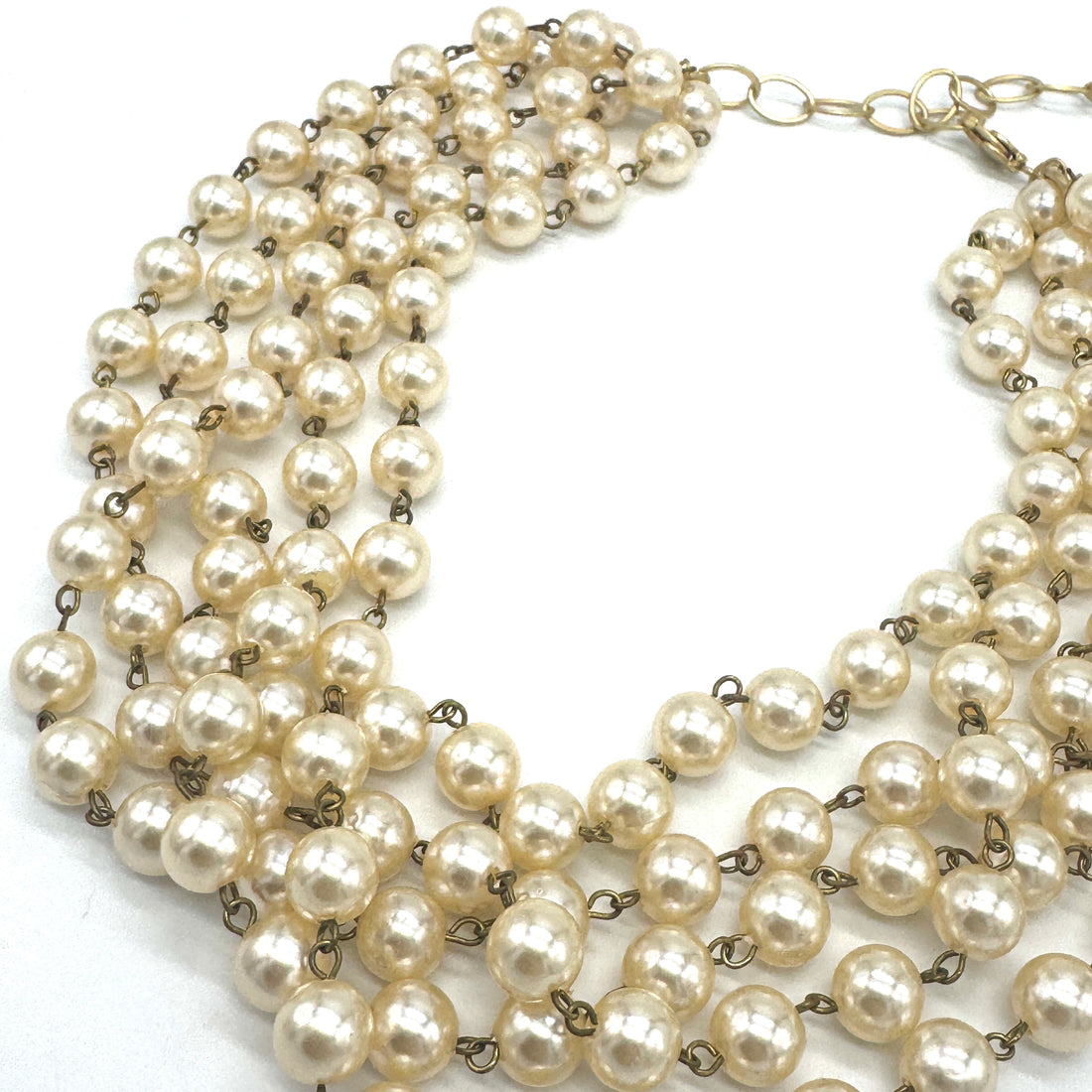 Multiple strands of pearl necklace on a white background
