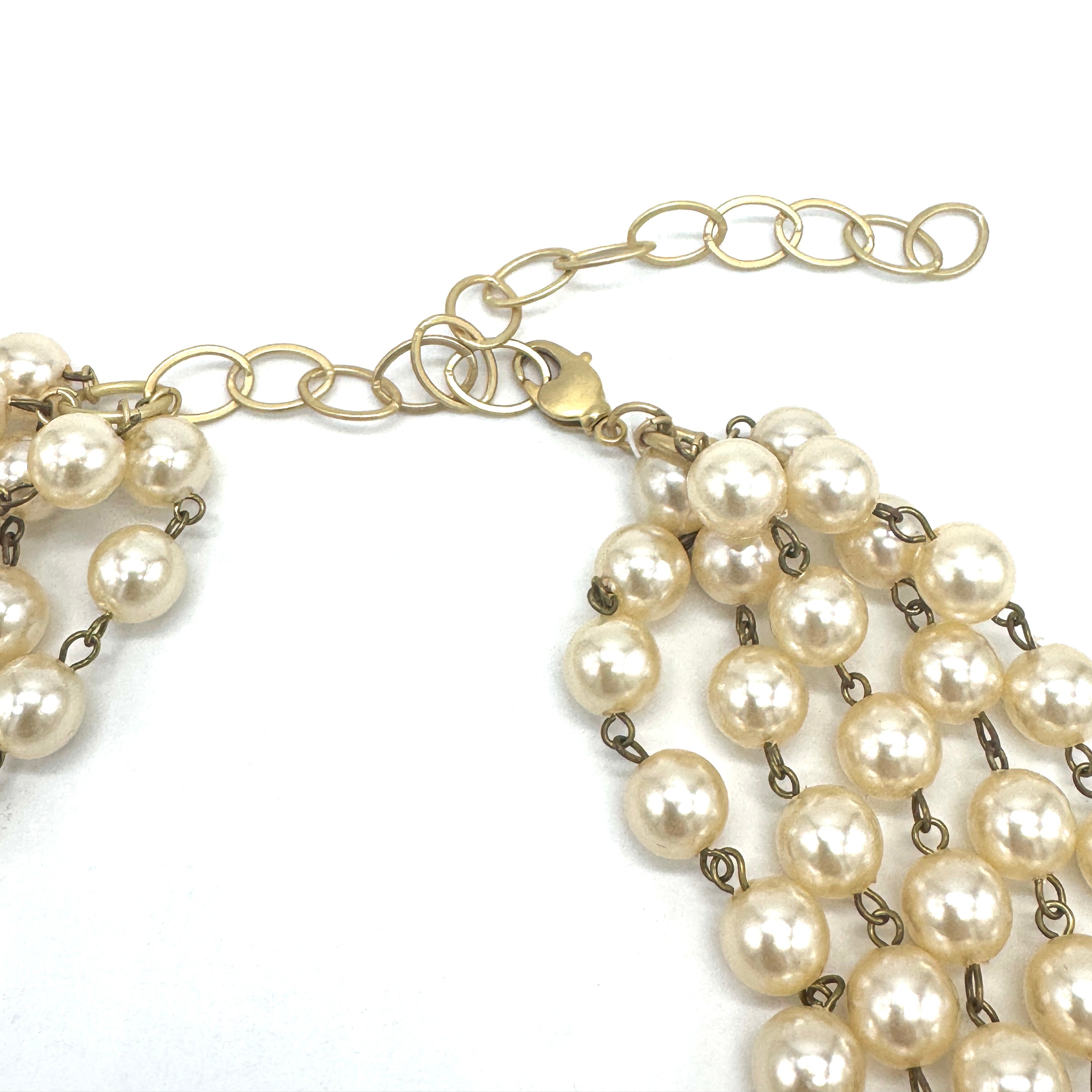 Pearl necklace with gold chain on a white background