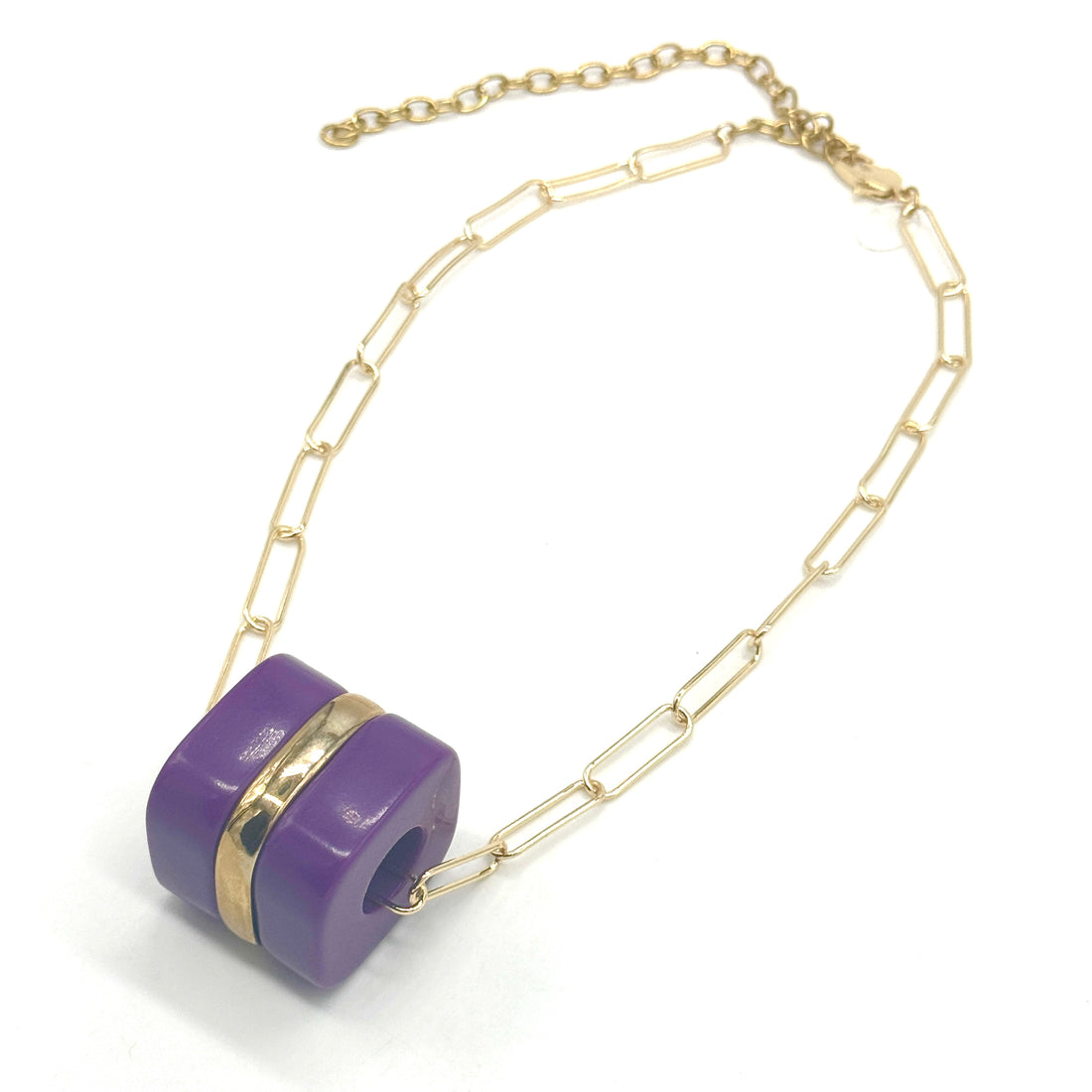 Necklace with a purple pendant and gold chain on a white background