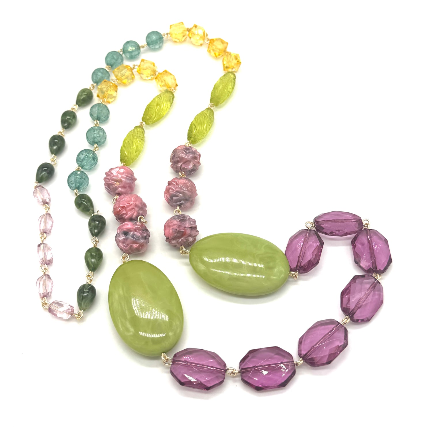 Colorful beaded necklace with green, purple, and yellow beads on a white background