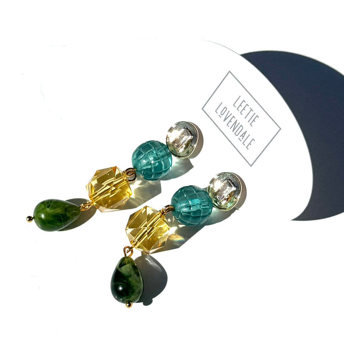 Colorful beaded earrings on a white background with &