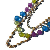 Colorful beaded necklace with blue, green, and purple beads on a white background