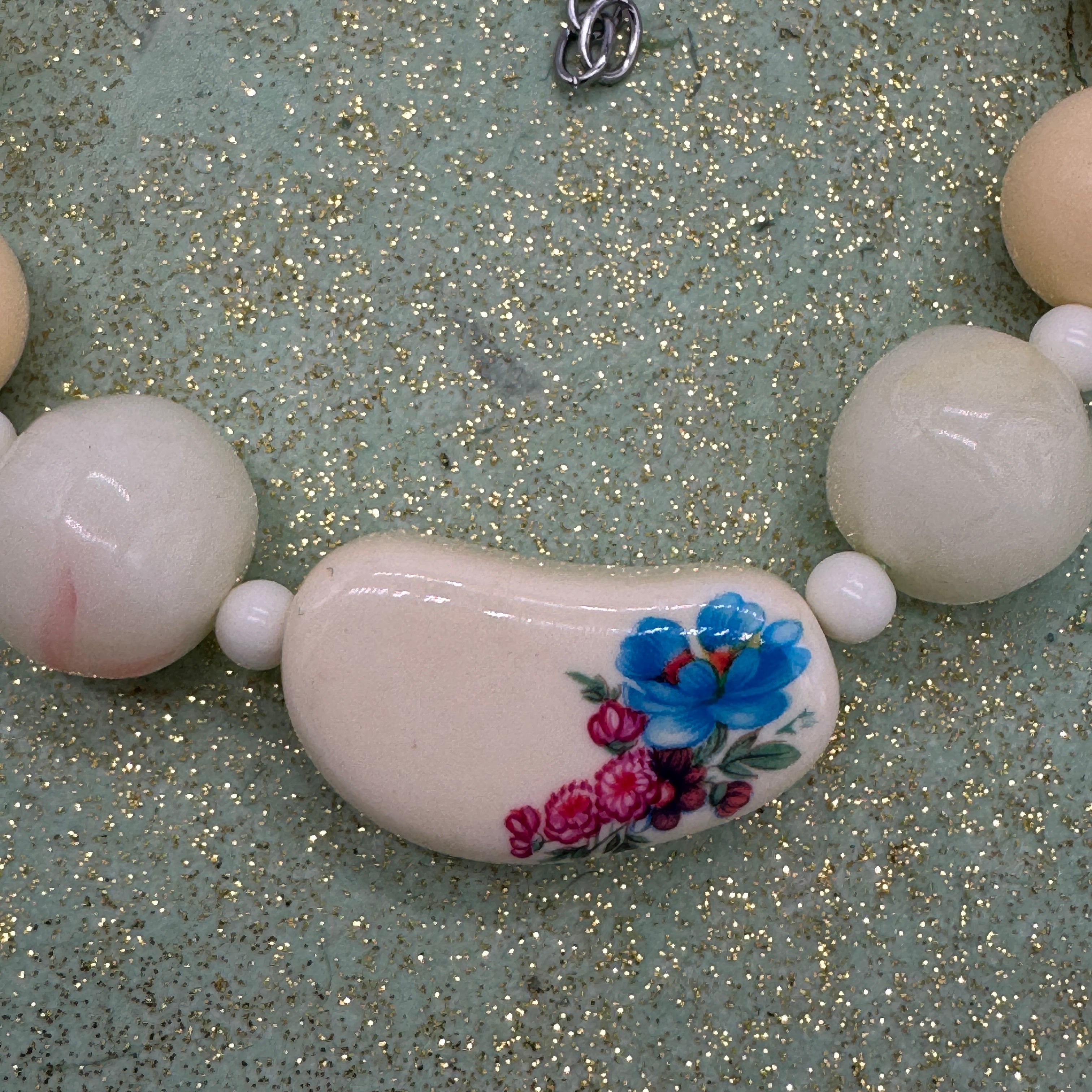 Necklace with a floral bead on a glittery background
