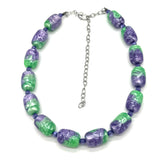 Necklace with purple and green beads on a white background