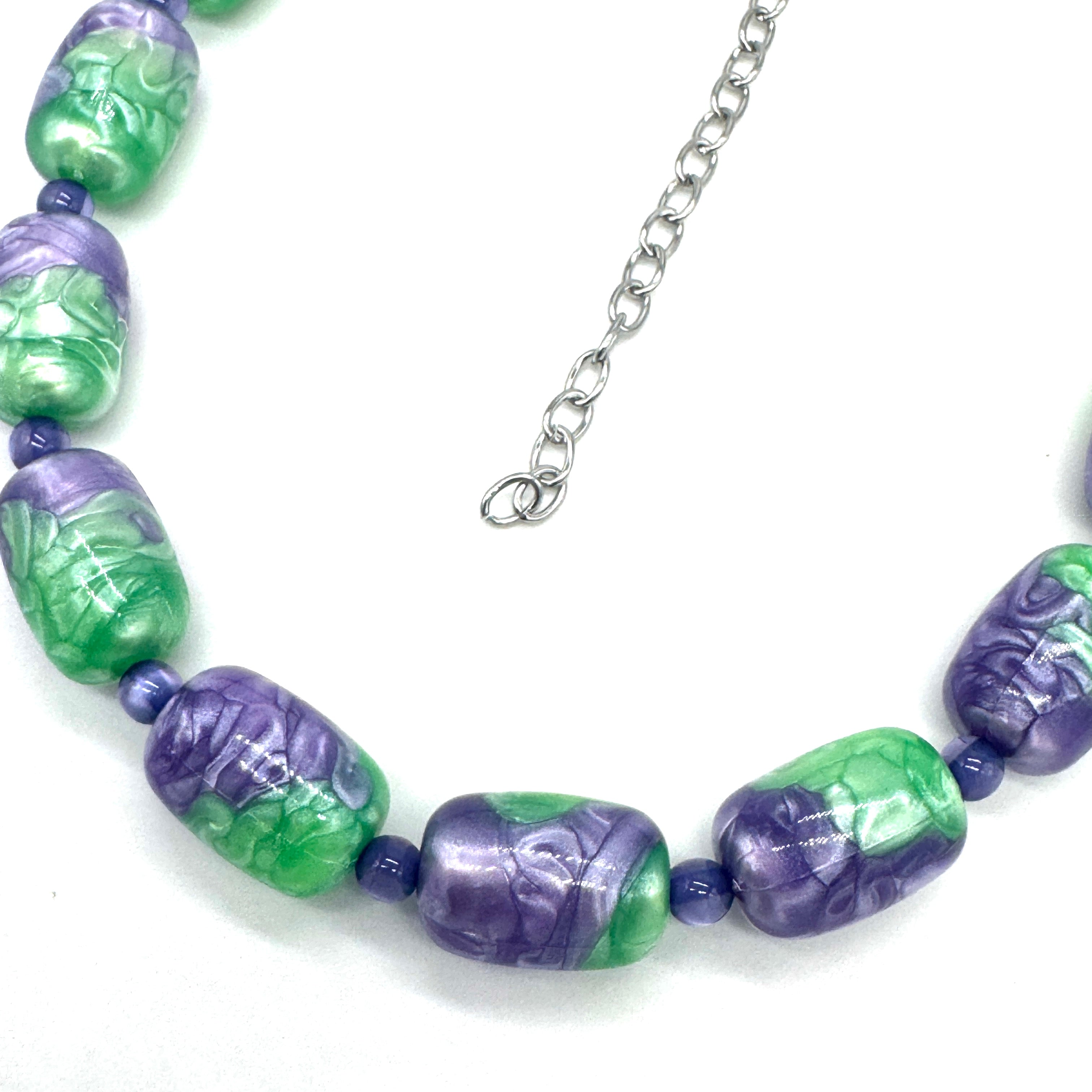 Necklace with green and purple beads on a white background