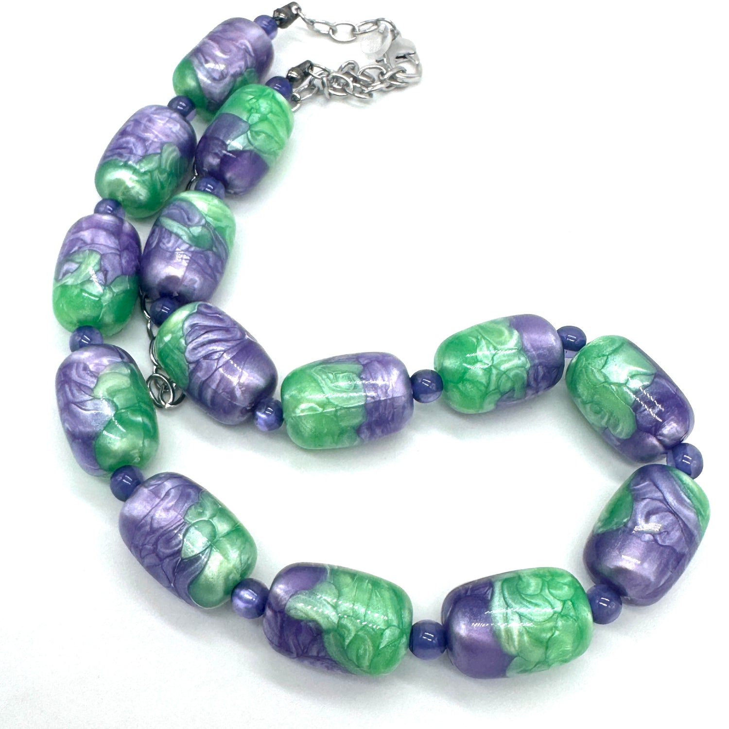 Necklace with green and purple beads on a white background