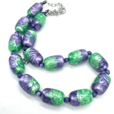 Necklace with green and purple beads on a white background