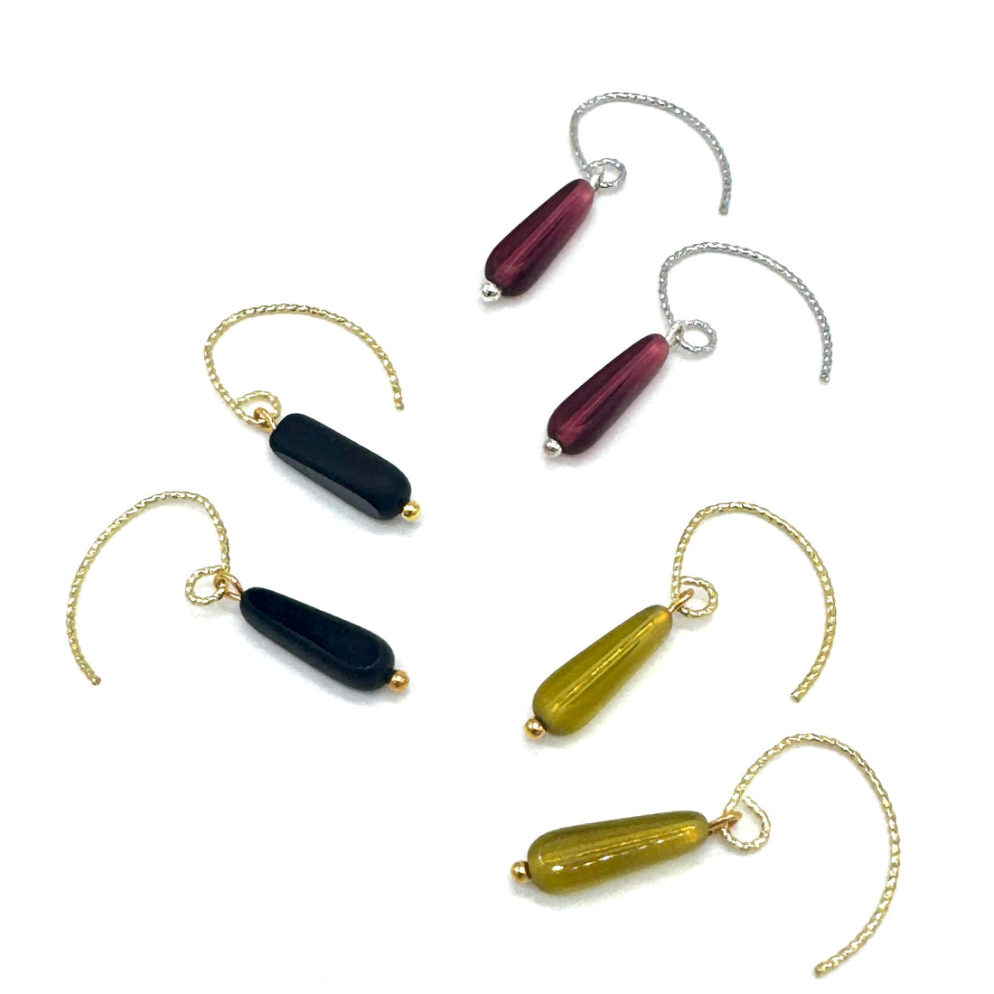 Set of three earrings with different colored beads on a white background