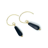 Black earrings with gold chains on a white background