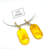 Yellow earrings on a white background with &
