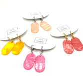 Set of earrings with colorful dangles on a white background, featuring the brand &