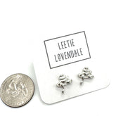 Silver frog-shaped earrings on a card with &