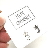 Silver star-shaped earrings held above a card with &