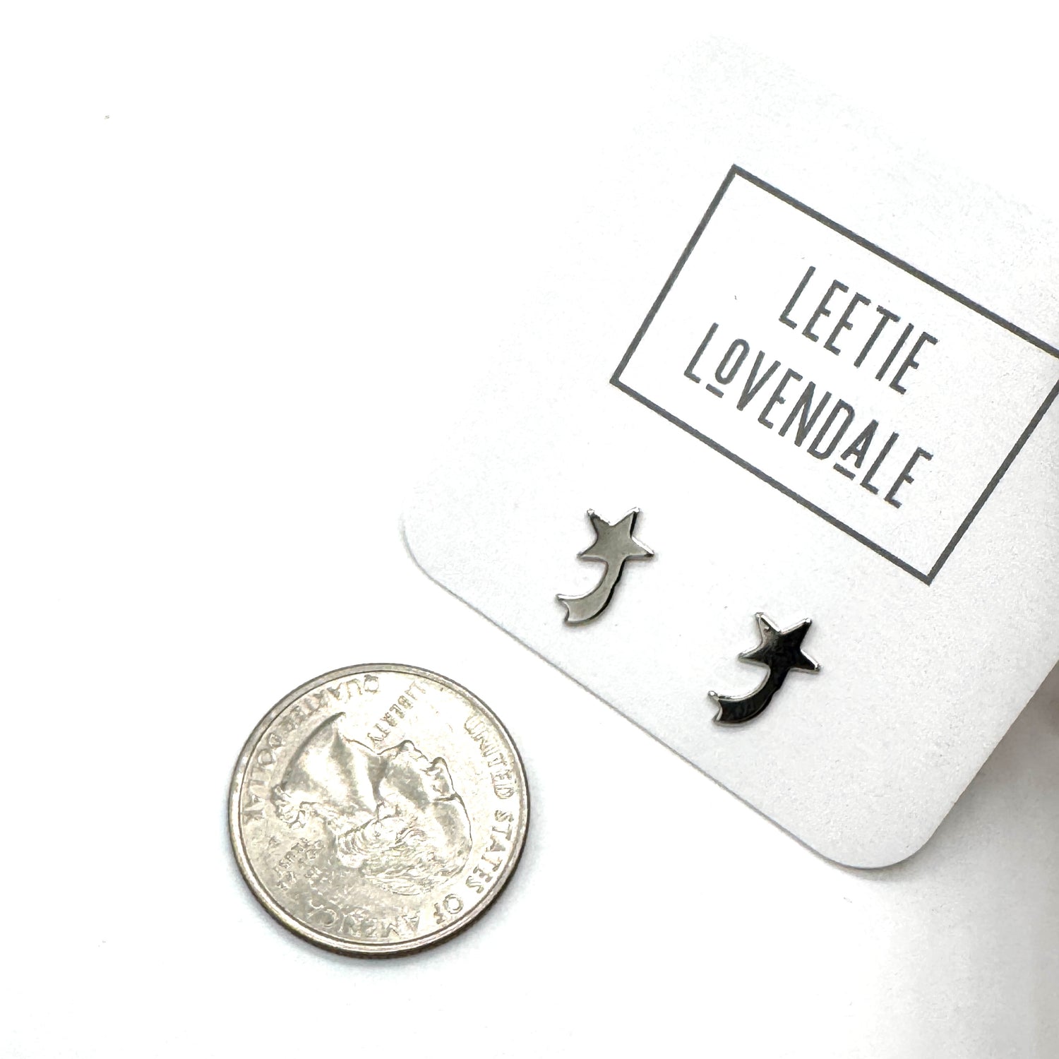 Silver shooting star earrings on a white card with &