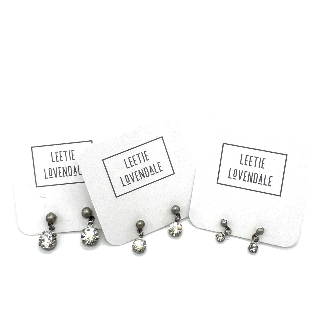 Pairs of earrings on display cards with &
