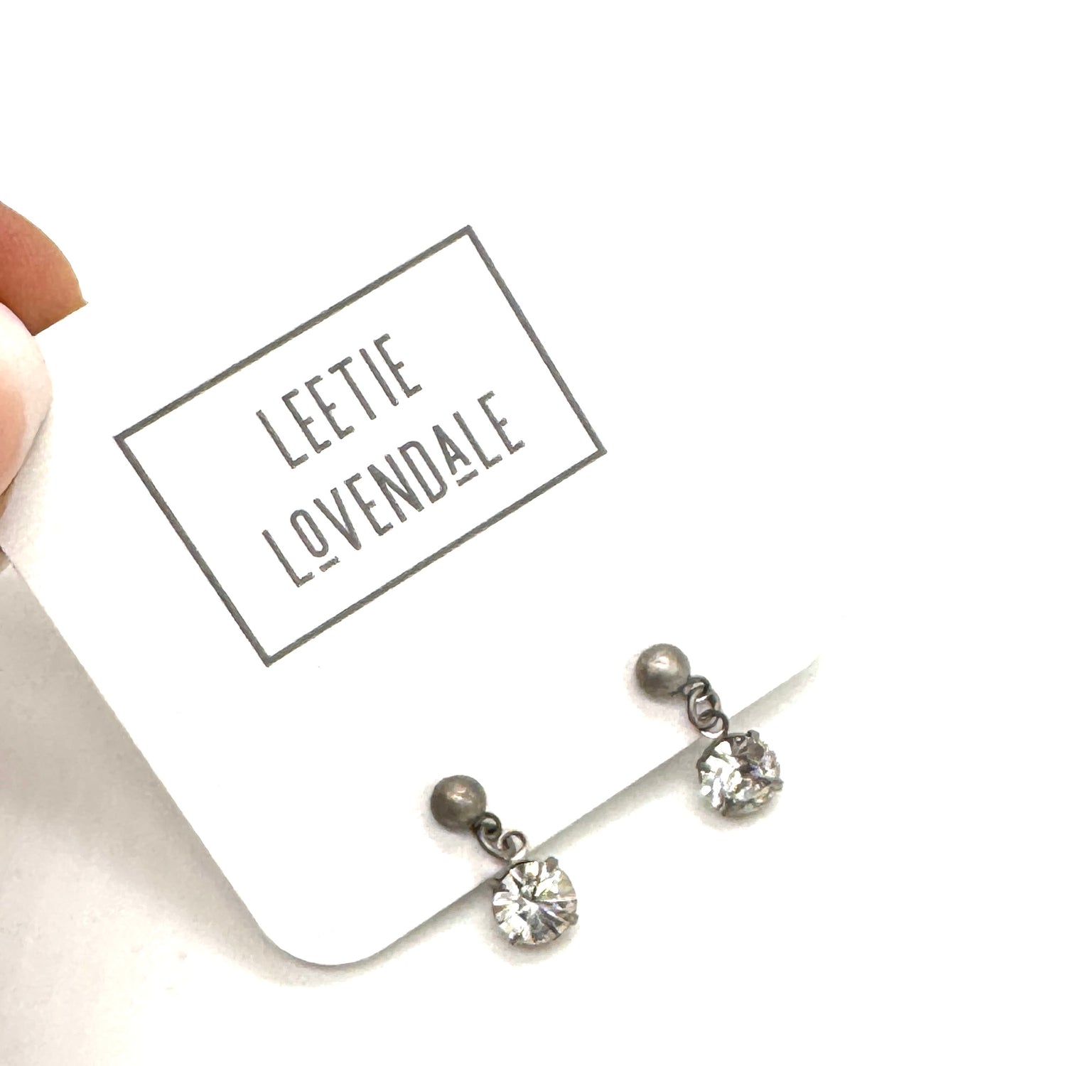 Pair of earrings on a white card with &