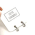 Pair of earrings on a white card with &