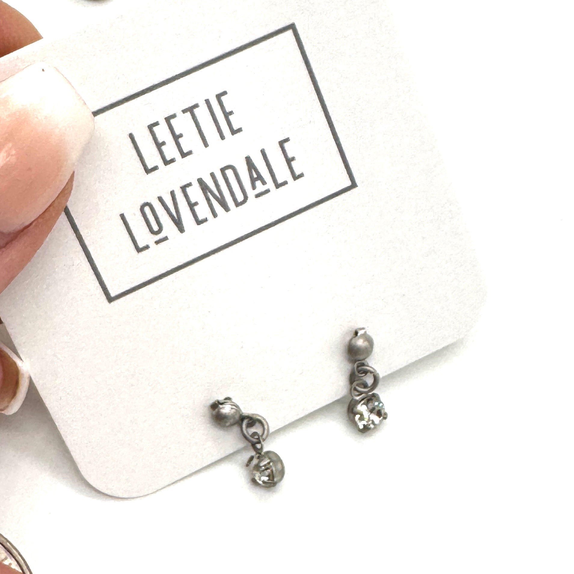 Silver earrings on a card with &