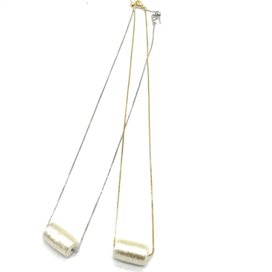 Two necklaces with gold and silver chains on a white background