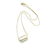 Necklace with a cylindrical pendant on a white background
