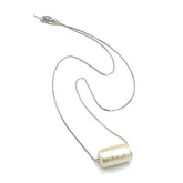 Silver necklace with a cylindrical pendant on a white background