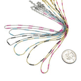 Set of colorful beaded necklaces with a coin for scale on a white background
