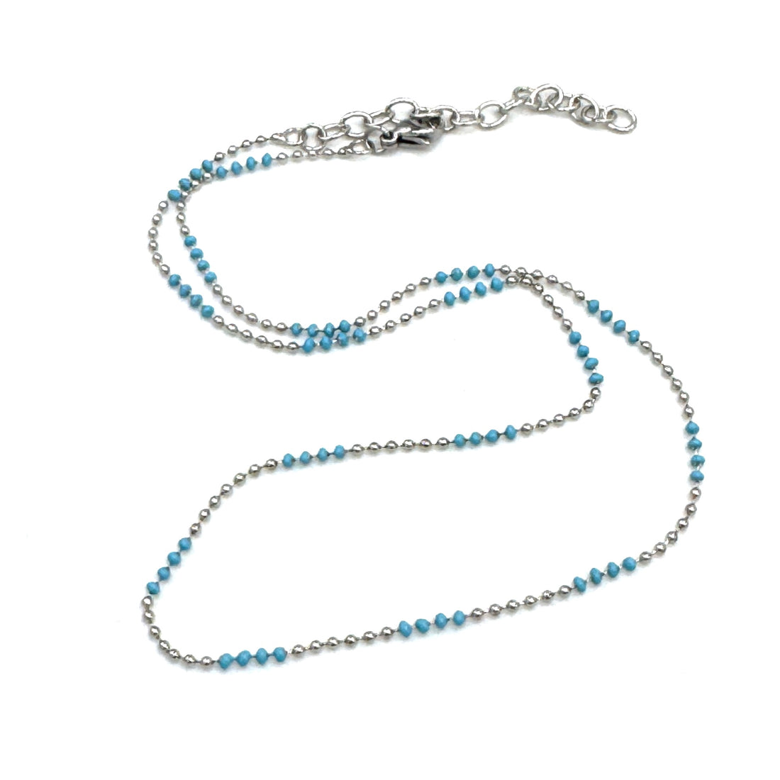 Necklace with blue beads and silver chain on a white background