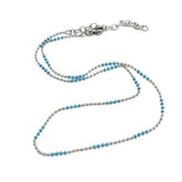 Necklace with blue beads and silver chain on a white background