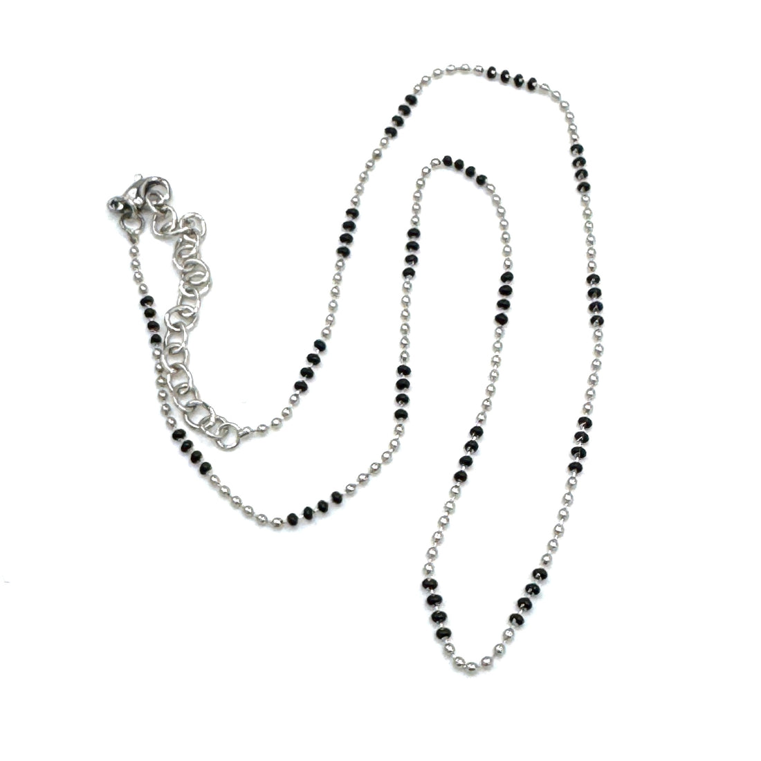 Silver necklace with black beads on a white background