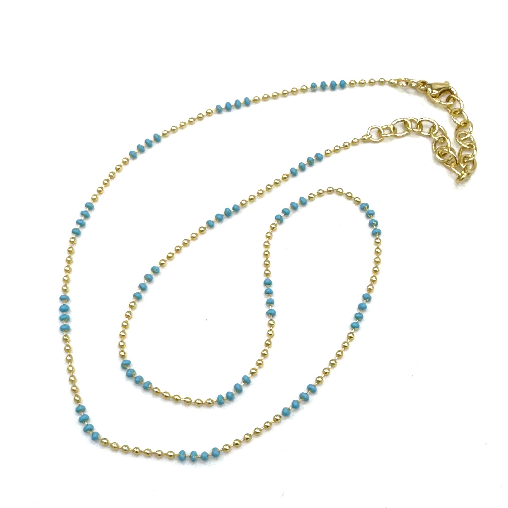 Gold and blue beaded necklace on a white background
